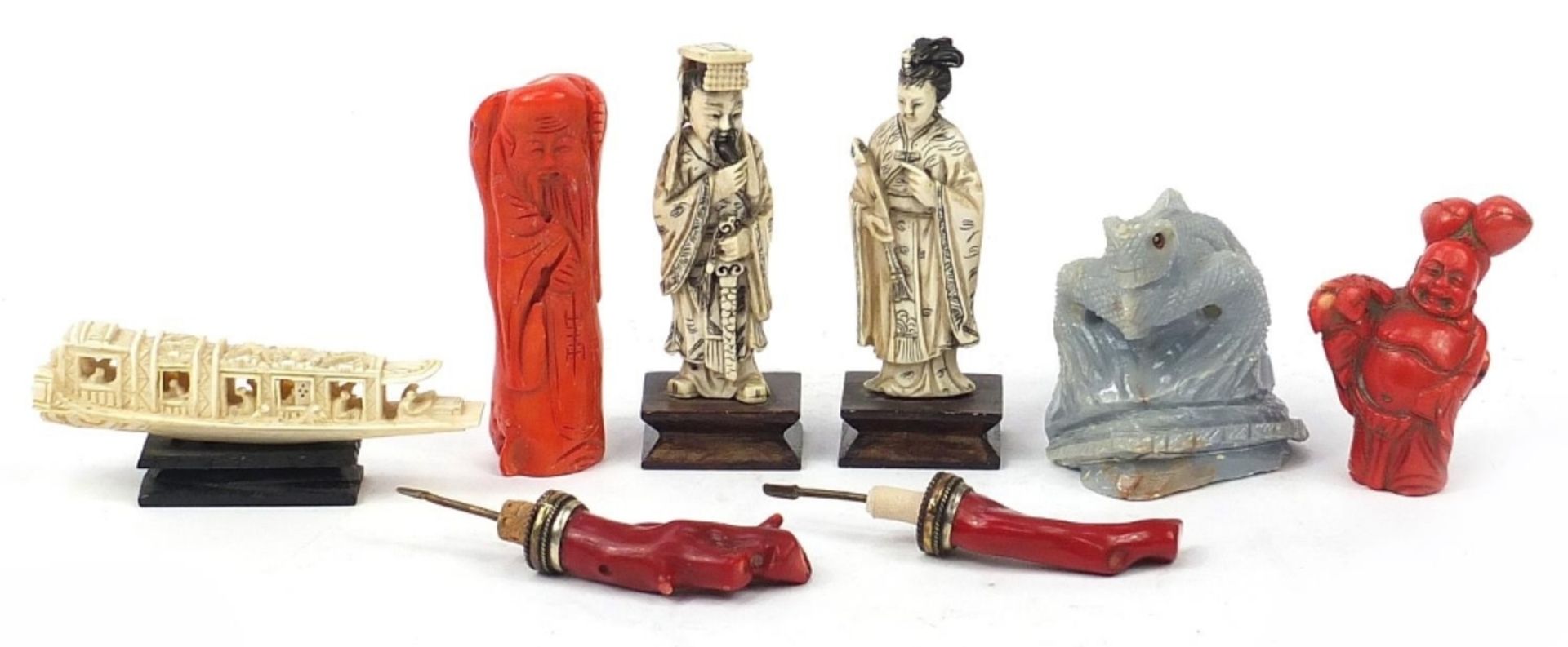 Chinese carvings including two ivory okimonos raised on rectangular wood bases, two coral carvings