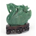 Chinese green jadeite carving of a duck raised on carved hardwood stand, 14cm in length : For