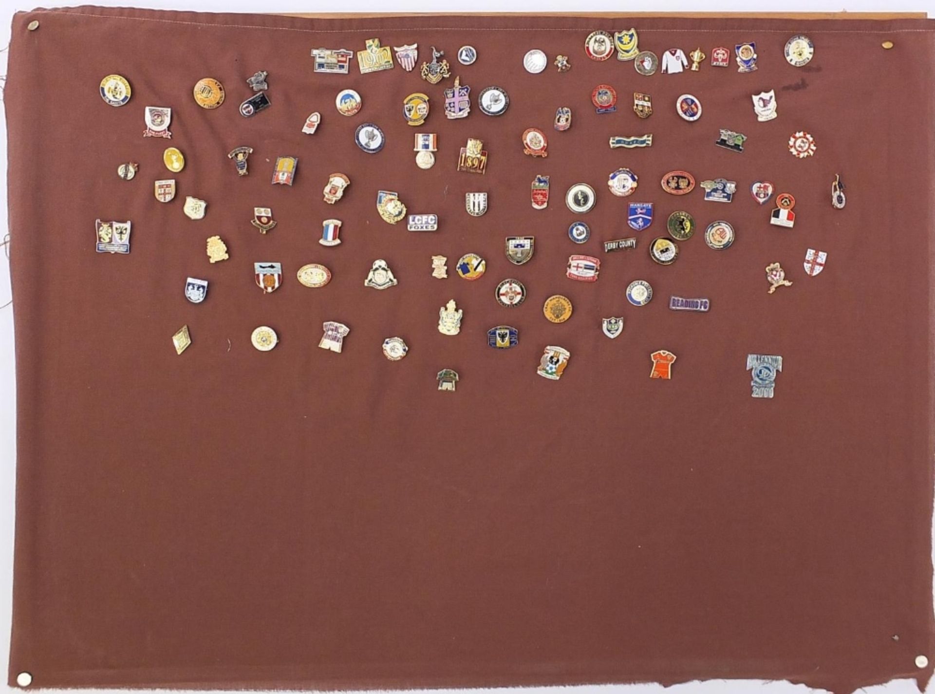 Vintage and later pin badges arranged in a board, mostly football related including Paris St