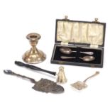 Silver and white metal objects including candle snuffer, candlestick, cake slice and teaspoons,
