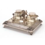 19th century silver plated desk stand with two cut glass inkwells surmounted with a lion, 23.5cm