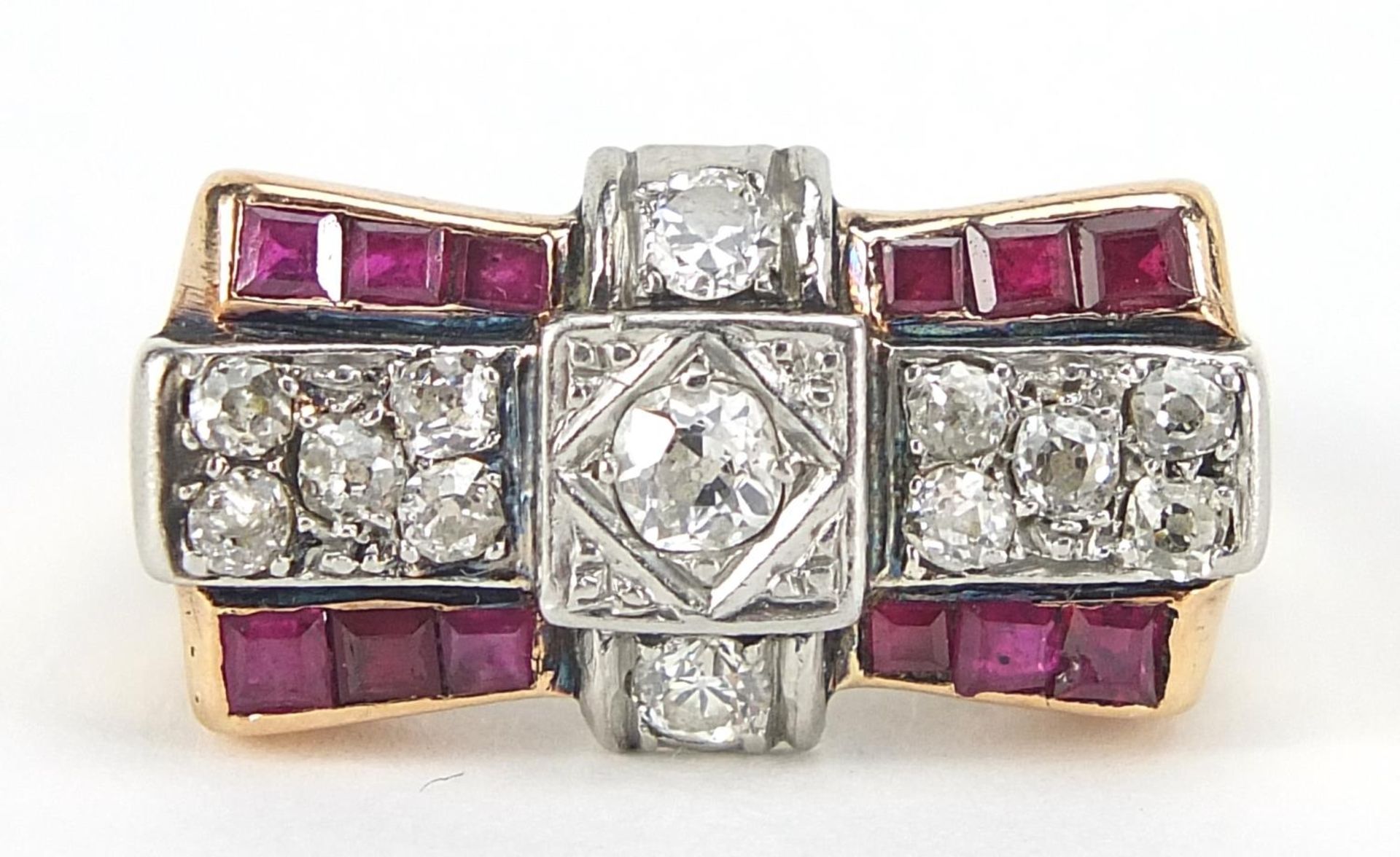 Art Deco unmarked gold diamond and ruby ring of bow design, (tests as 15ct+ gold) the central