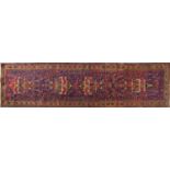 Rectangular Persian carpet runner decorated with vases and flowers onto a midnight blue ground,