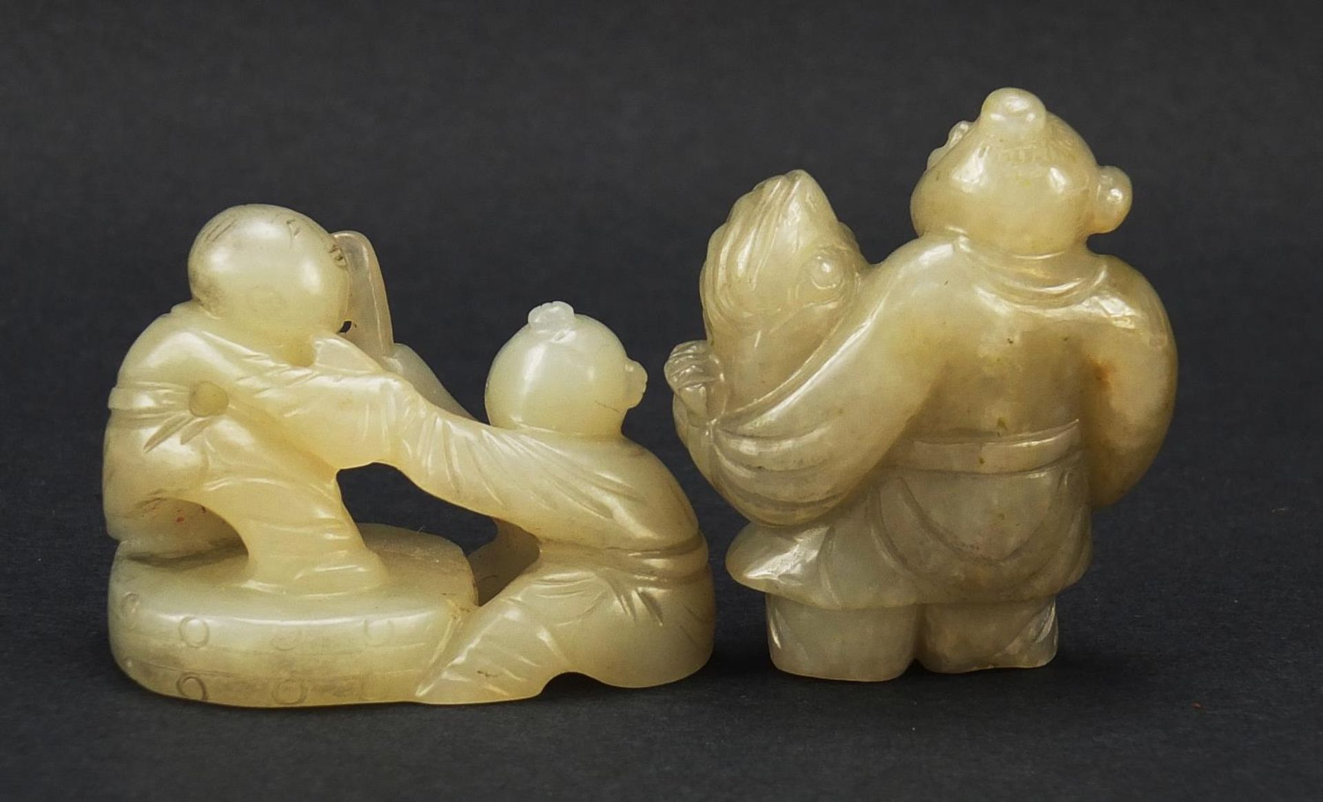 Two Chinese celadon and russet jade carvings including one of a figure holding fruit, the largest - Image 4 of 7