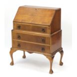 Walnut quarter veneered bureau with drop down front and fitted interior above three drawers and ball