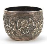 Tibetan silver cup profusely embossed with birds and wild animals amongst foliage, 3.5cm high, 44.4g