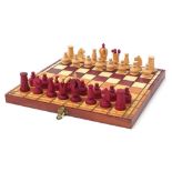 Carved wood half stained chess set with fitted folding chess board, the largest pieces each 6.5cm