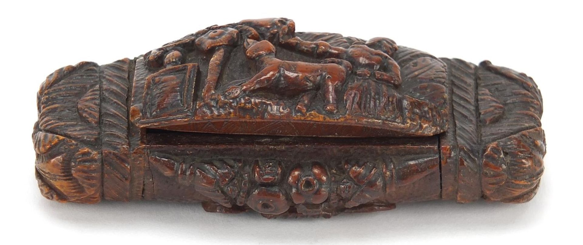Antique coquilla nut snuff box carved with figure and dog beside a tree and an Irish rose, 10cm wide