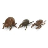 Three Japanese patinated bronze okimonos including a stag beetle, each character marks to the