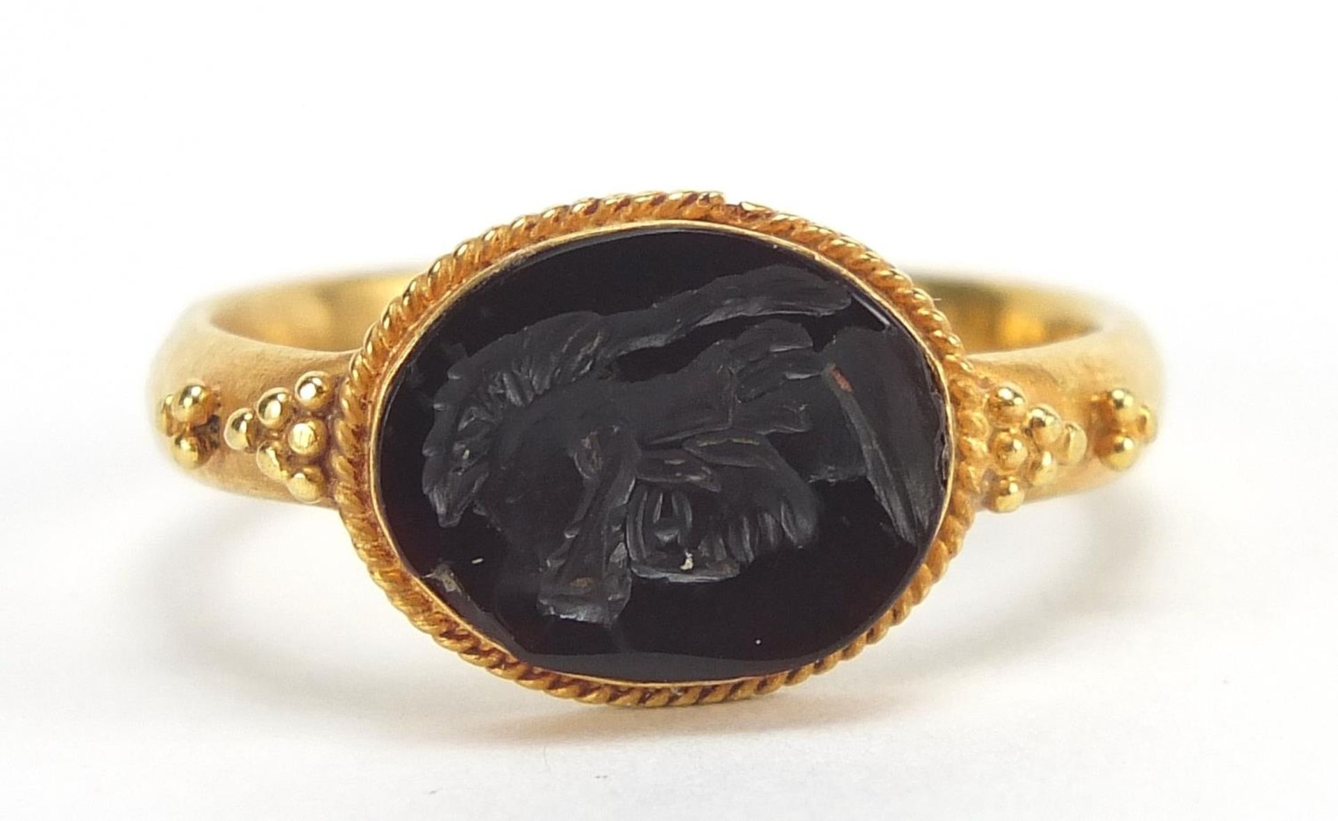 Antique unmarked gold intaglio seal ring carved with a gladiator head, (tests as 15ct+ gold) size Q,