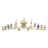 Continental porcelain figures including a floral encrusted mantle clock with garniture vases with