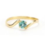 Unmarked gold blue stone solitaire crossover ring, (tests as 18ct gold) size O, 0.9g : For Further