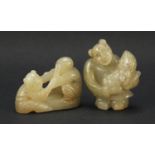 Two Chinese celadon and russet jade carvings including one of a figure holding fruit, the largest