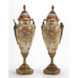 Pair of Continental vases and covers with bronze mounts, each decorated with instruments and