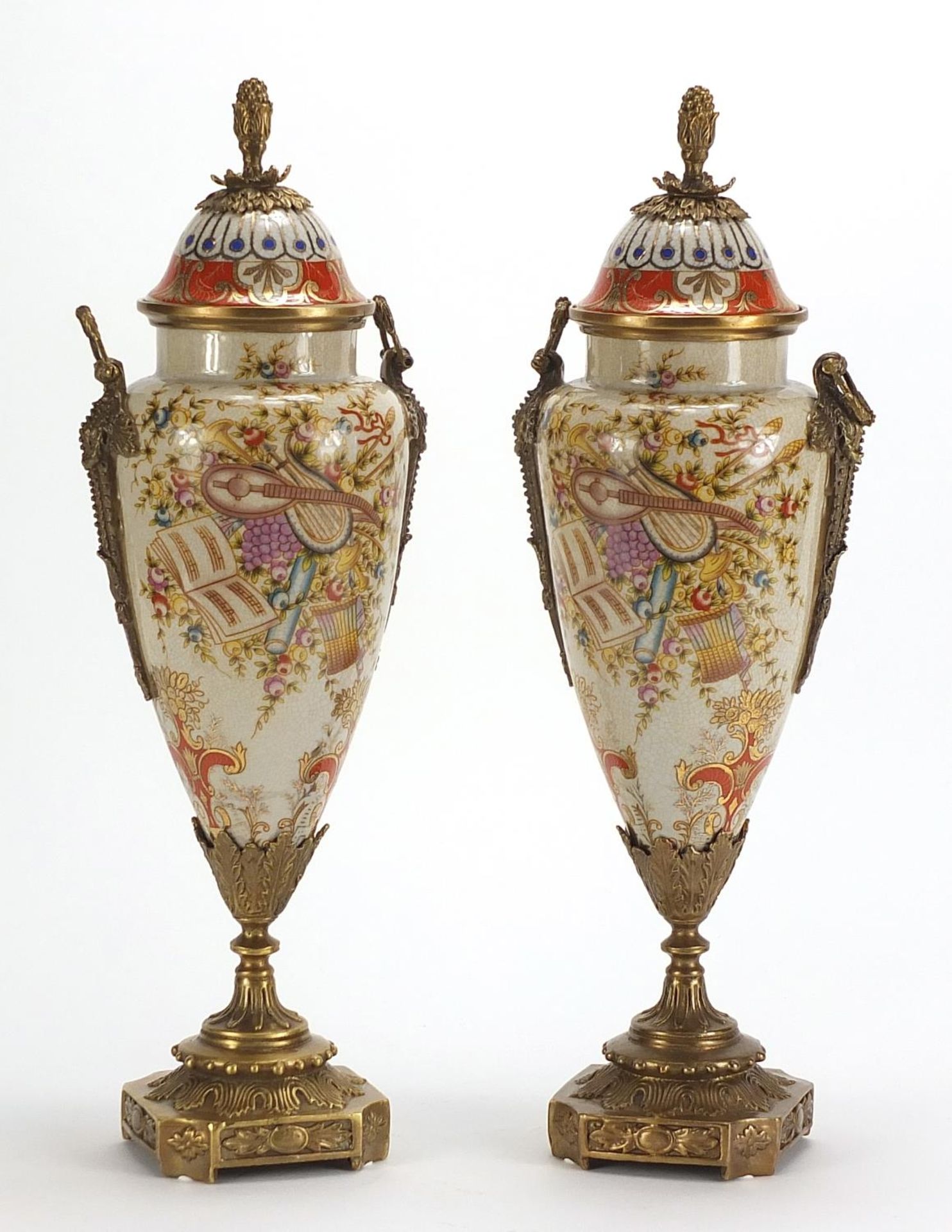 Pair of Continental vases and covers with bronze mounts, each decorated with instruments and