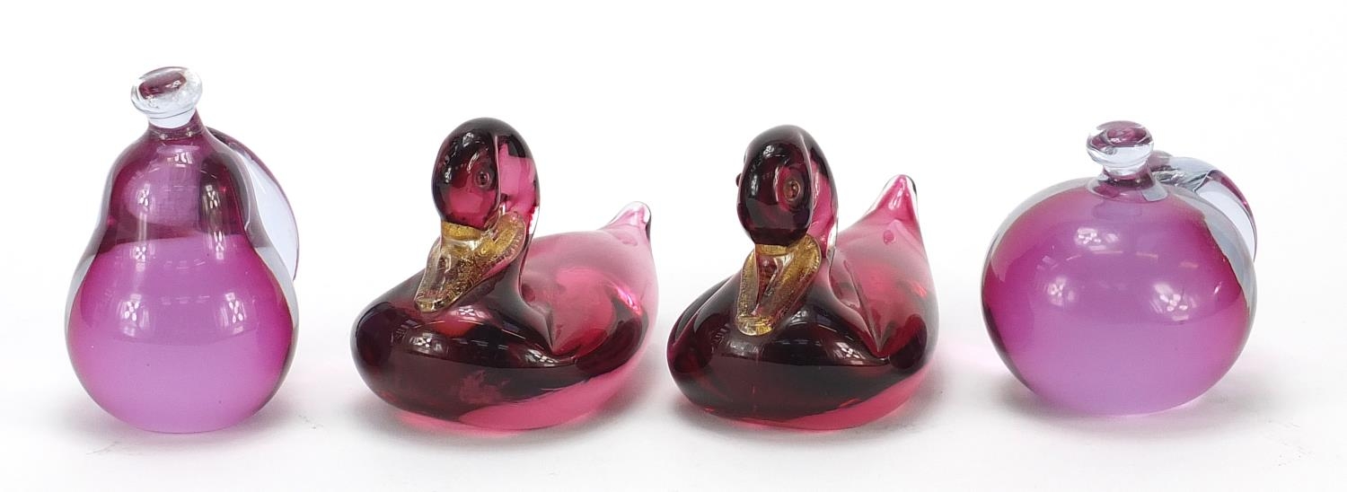 Four Murano glass paperweights comprising two gold flecked ducks and two of fruit with paper labels,