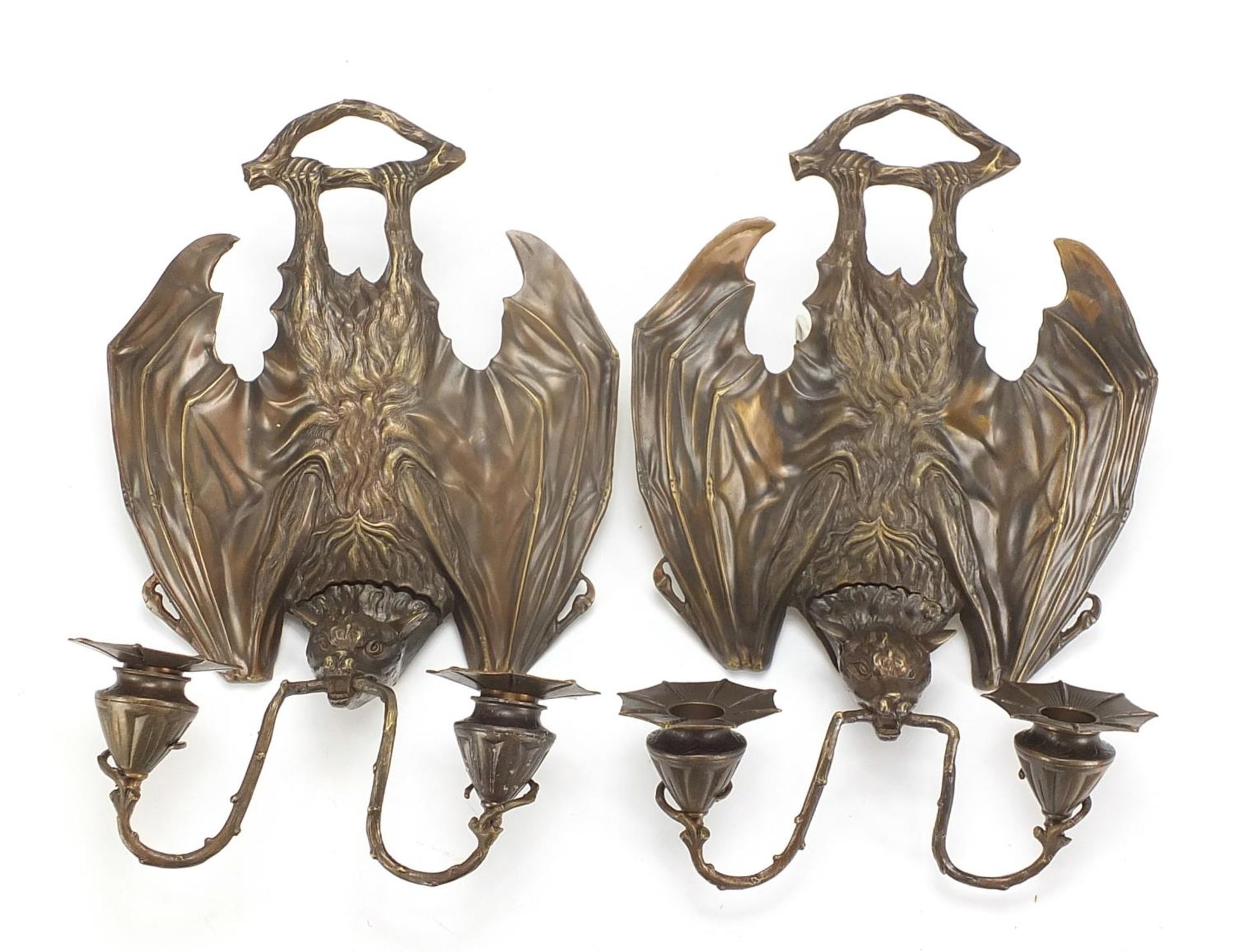 Pair of Art Nouveau style patinated bronze two branch bat design wall sconces, each 36cm high :