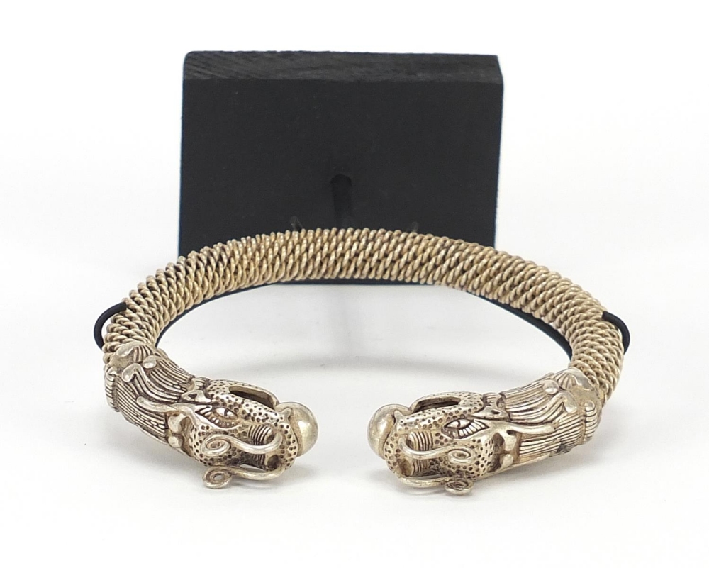 Tibetan silver coloured metal dragon bangle on stand, 17cm high : For Further Condition Reports - Image 6 of 7