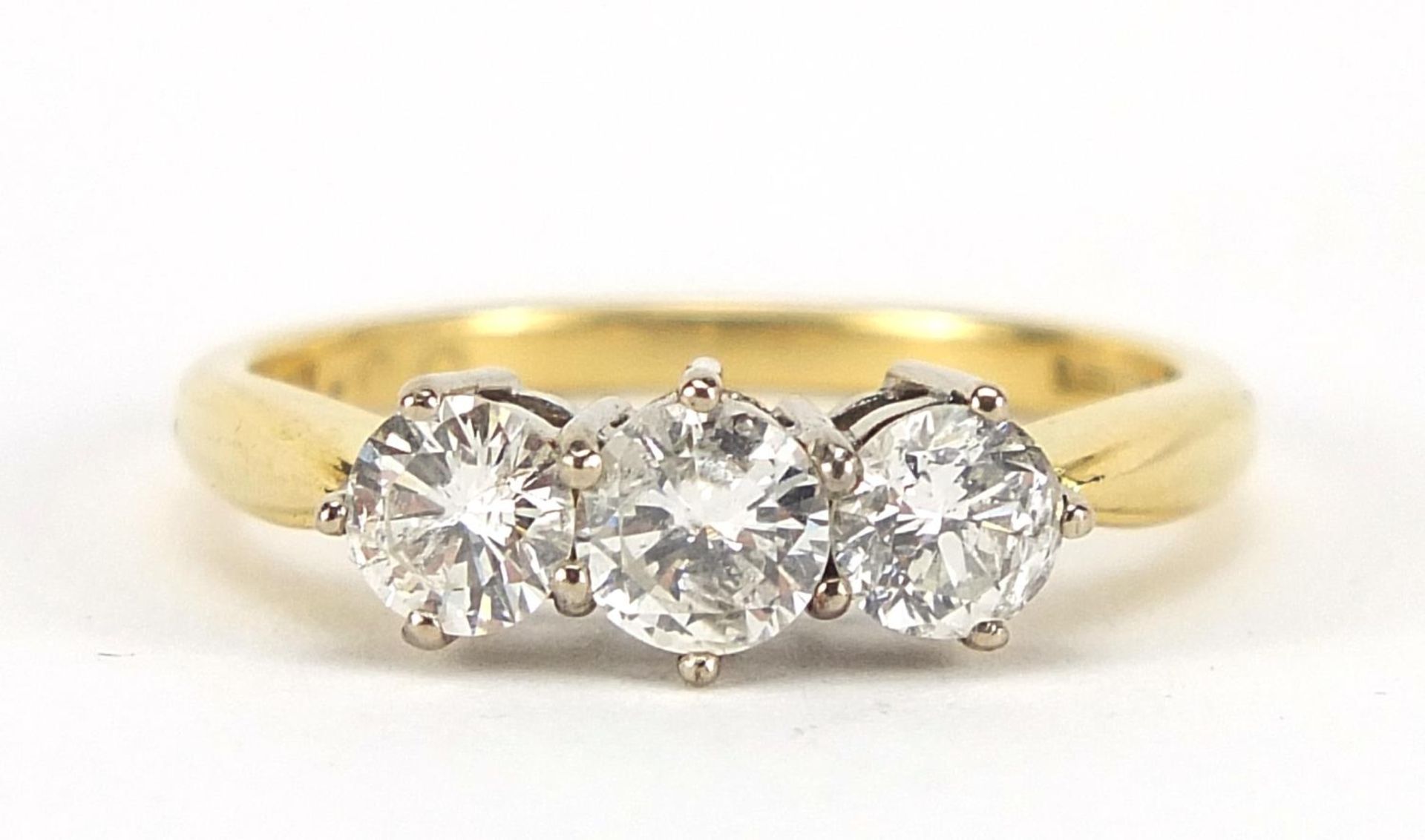 18ct gold diamond three stone ring, the central diamond approximately 4.2mm in diameter, size O, 3.