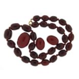 Cherry amber coloured bead necklace and three beads, the necklace 48cm in length, total 49.7g :