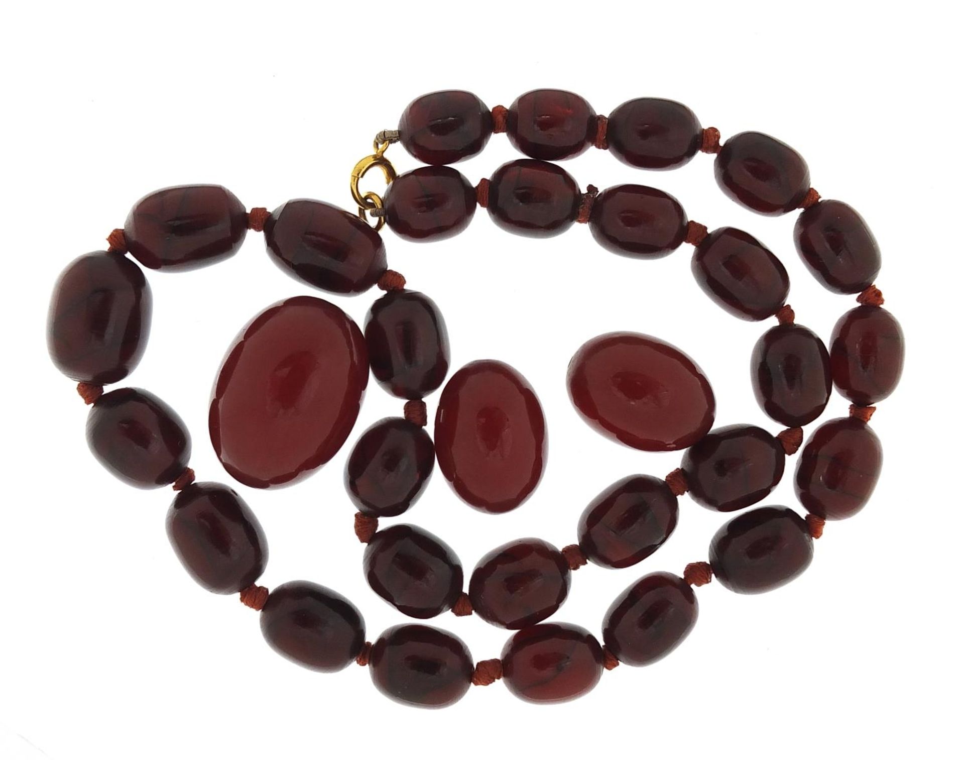 Cherry amber coloured bead necklace and three beads, the necklace 48cm in length, total 49.7g :