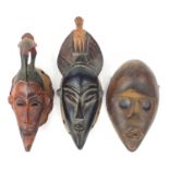 Three tribal interest African carved wood face masks, the largest 32.5cm high : For Further