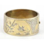 Victorian aesthetic silver gilt hinged bangle engraved with birds amongst bamboo, Birmingham 1886,
