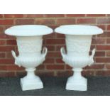Pair of white painted cast iron Campana urn planters with twin handles raised on square stepped