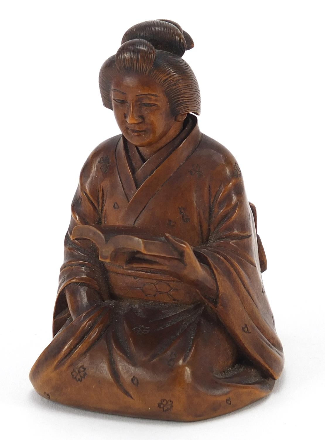 Japanese erotic carved hardwood okimono of a lady kneeling down reading a book, character mark to