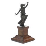 Patinated bronze dancing figure raised on a wooden base, 28cm high