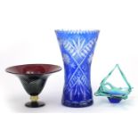 Art glassware including a blue flashed cut glass vase and a feathered pedestal bowl, the largest