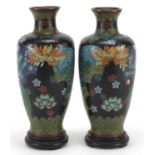 Pair of Japanese cloisonne vases raised on carved hardwood stands, each enamelled with flowers