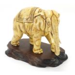 Ivory coloured porcelain model of an elephant on wooden stand, blue anchor mark under one foot,
