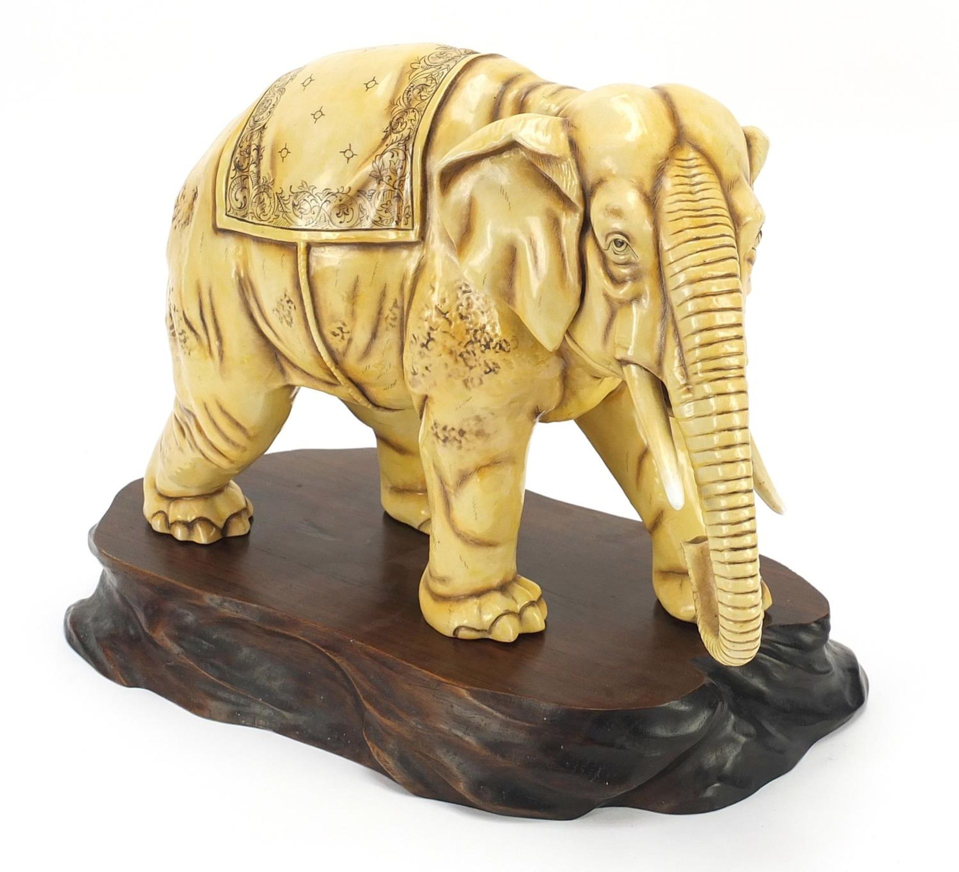 Ivory coloured porcelain model of an elephant on wooden stand, blue anchor mark under one foot,