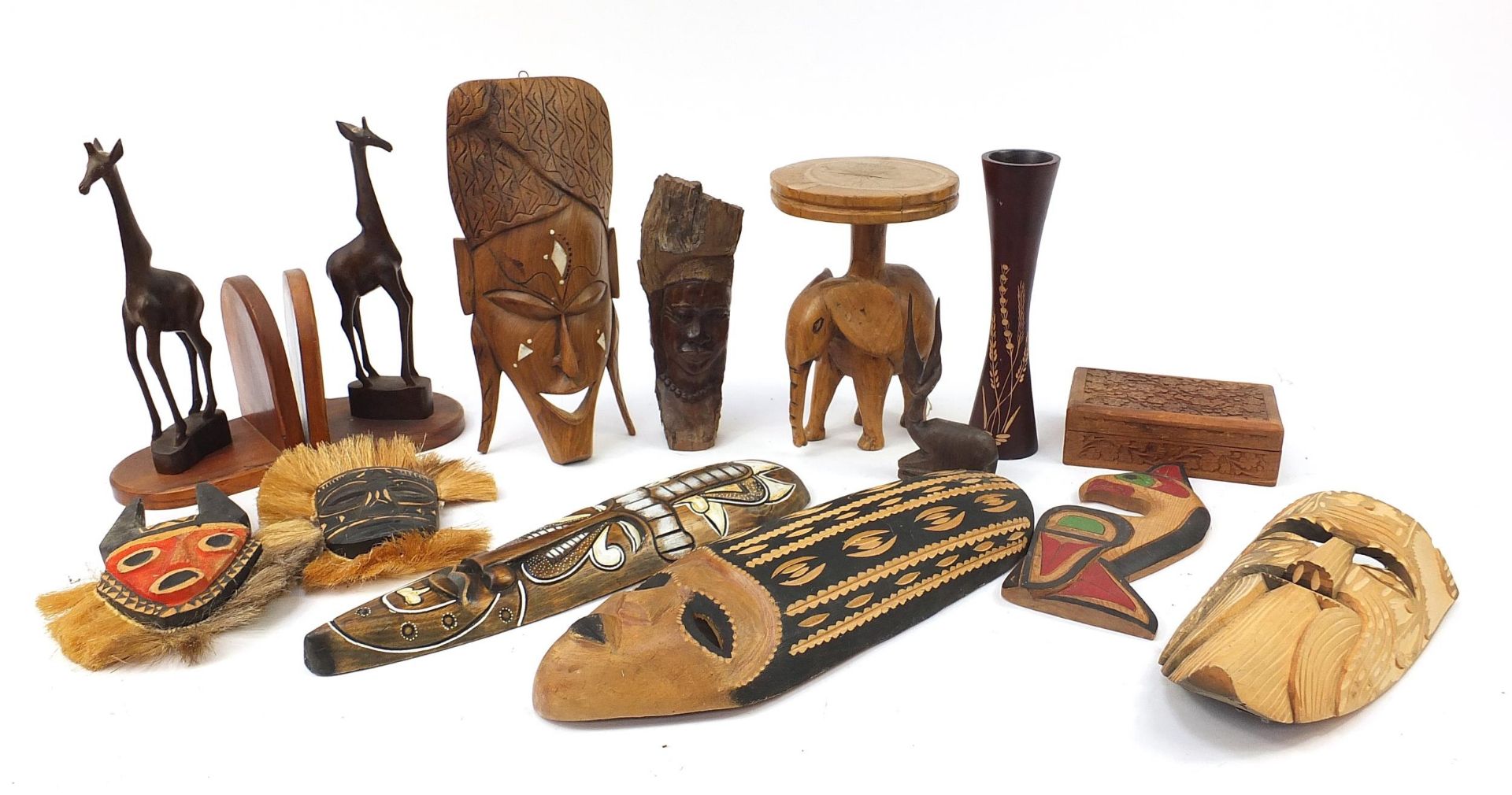 Tribal wood carvings to include African face masks, stool, giraffe bookends, carved box, the largest