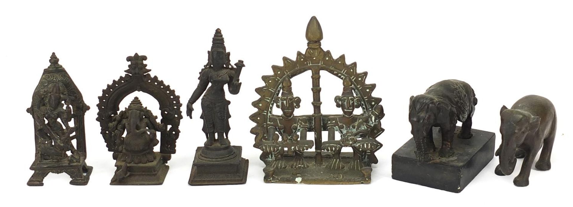 Indian bronzes including votive figures and two elephants, one raised on a rectangular black slate