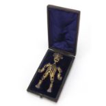 Antique bronze articulated model/pendant of a man housed in a fitted leather case, 12cm high