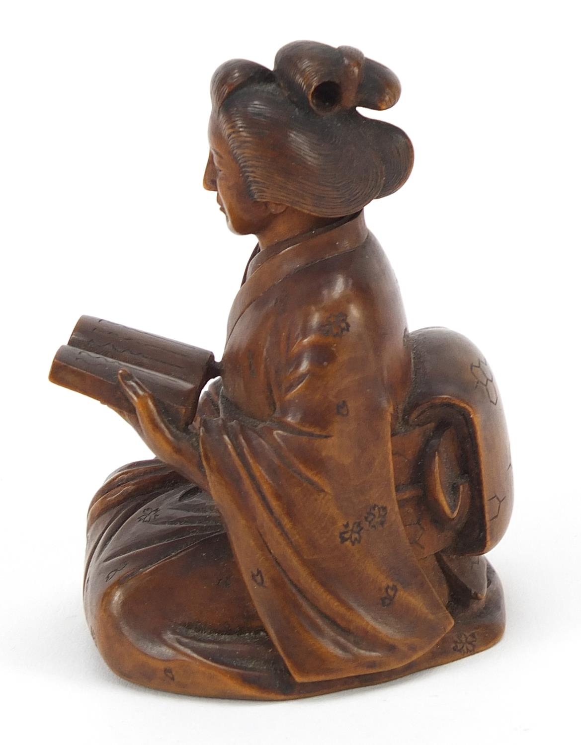 Japanese erotic carved hardwood okimono of a lady kneeling down reading a book, character mark to - Image 3 of 8