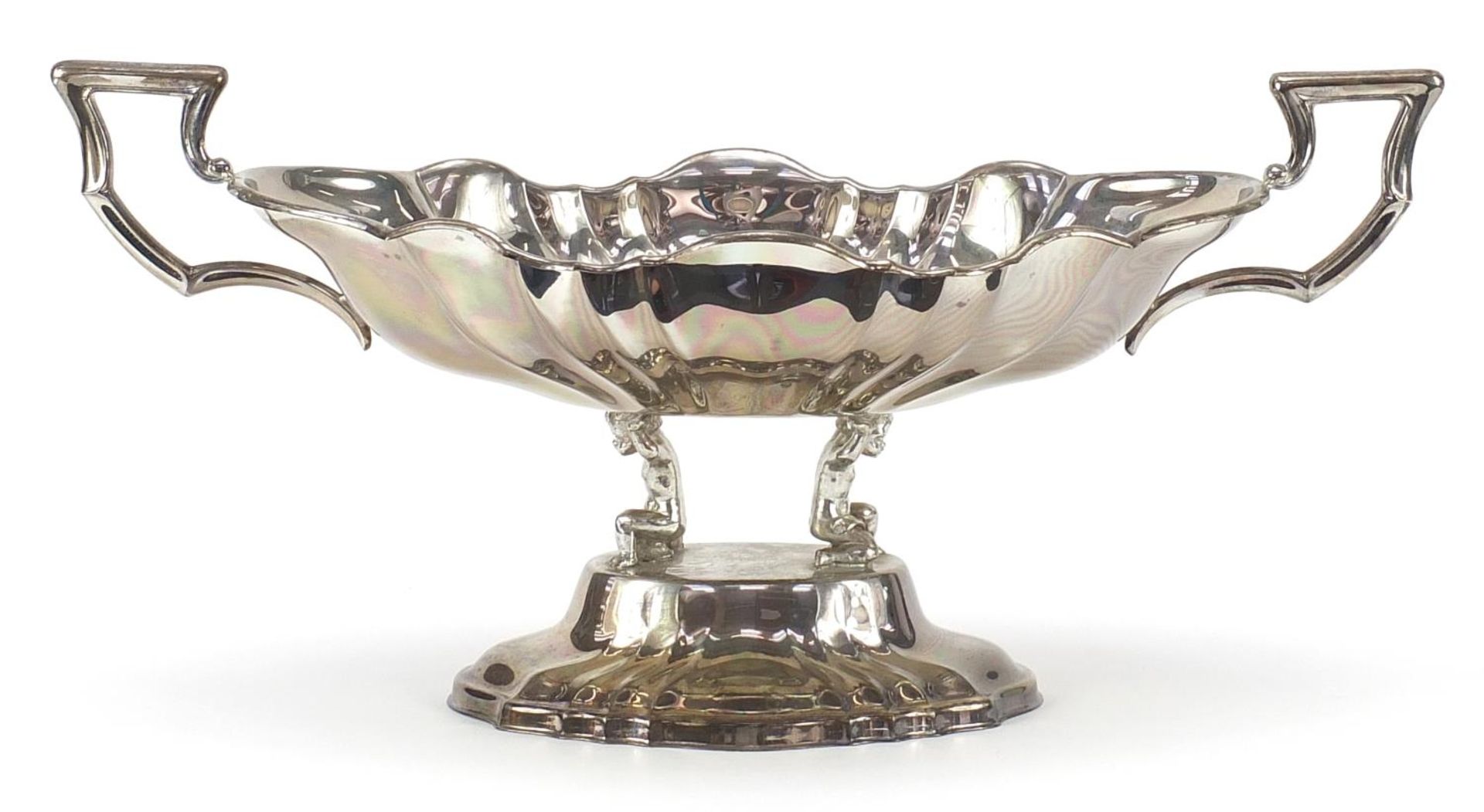 Large silver plated centrepiece with scalloped edges and handles on the end, supported by two