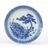 Chinese blue and white porcelain plate hand painted with a pine tree, foliage and a bird,