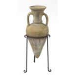 Greek terracotta amphora with twin handles, raised on a wrought iron stand, 87cm high