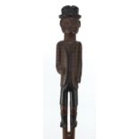 Tribal interest wooden short staff carved with a gentleman wearing a bowler hat and jacket, shorts