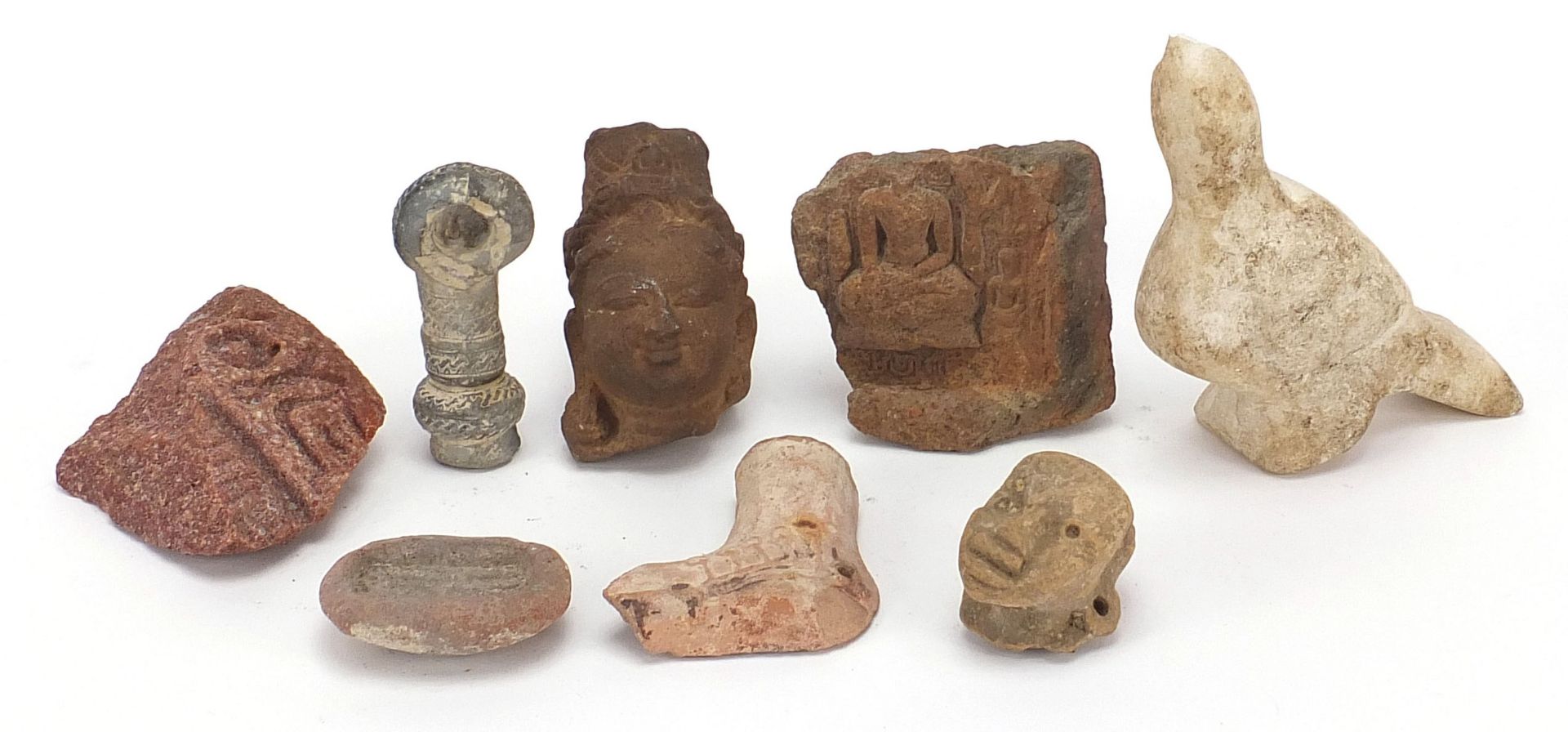 Stone antiquities including a marble carving of a bird and stone fragments, the largest 13cm high