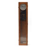 Oak cased electronic wall mounted clock having a silvered dial with Roman numerals, 126cm high