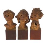 Three mid century pottery busts raised on wooden block bases, each inscribed Elizabeth Benenson to