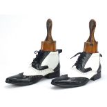 Pair of antique fruit wood shoe stretchers together with a pair of vintage black and white shoes