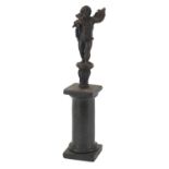 Antique cast metal figure of Putti raised on a marble column base, possibly Greek or Cypriot, 30cm