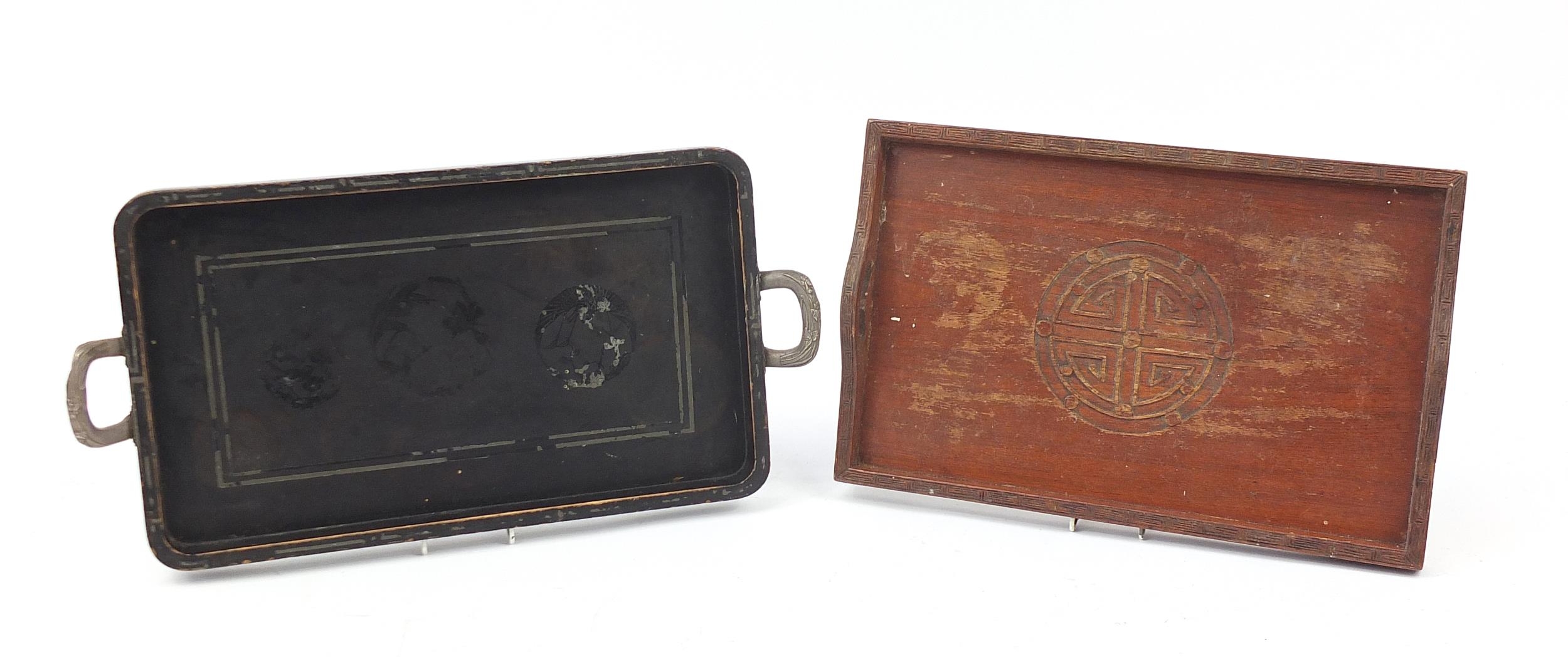 Two Japanese wooden trays, one lacquered in black and having white metal handles, the other having