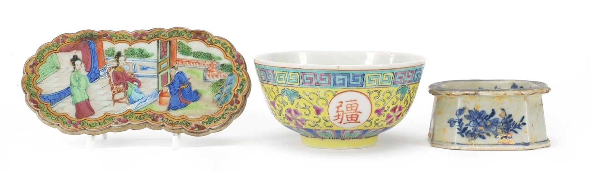 Chinese porcelain comprising a Canton wrist rest, blue and white salt and a famille rose bowl, the