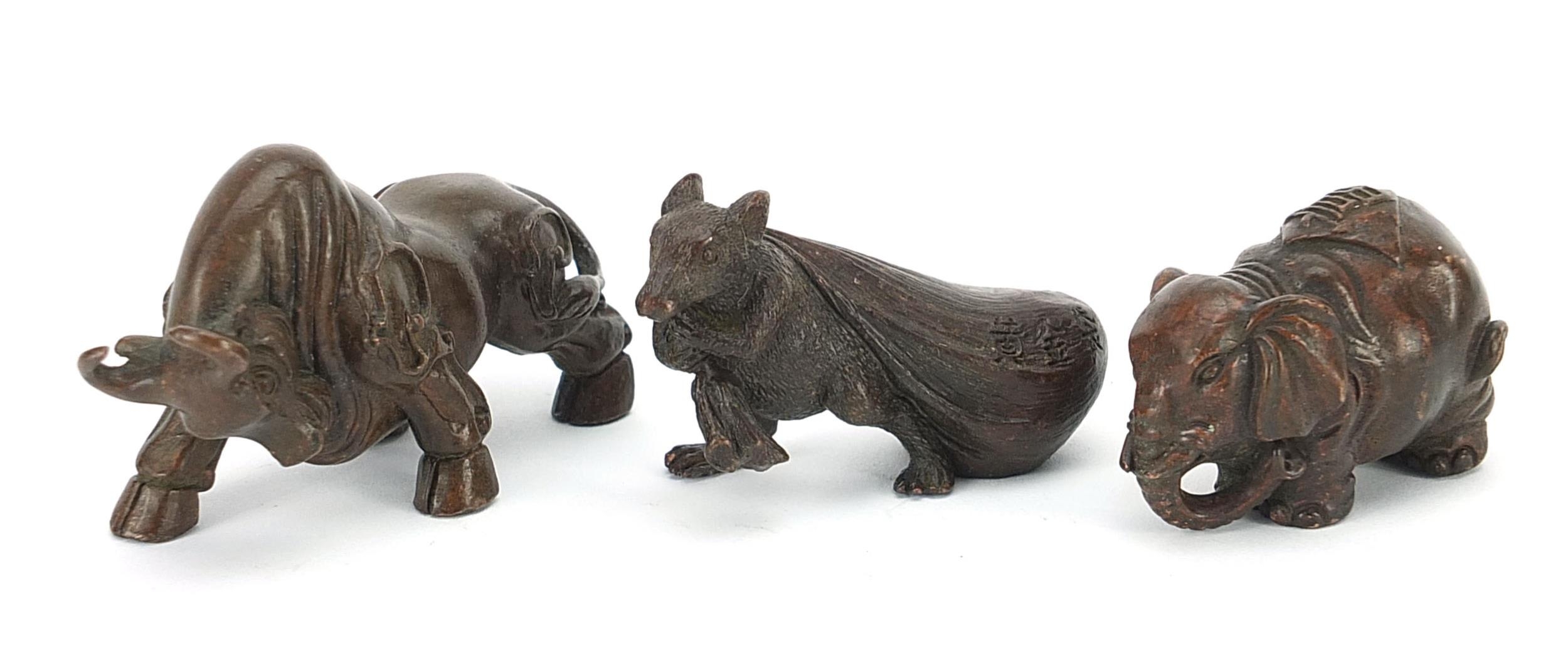 Three Japanese patinated bronze animals comprising bull, rat with a sack and elephant, each with